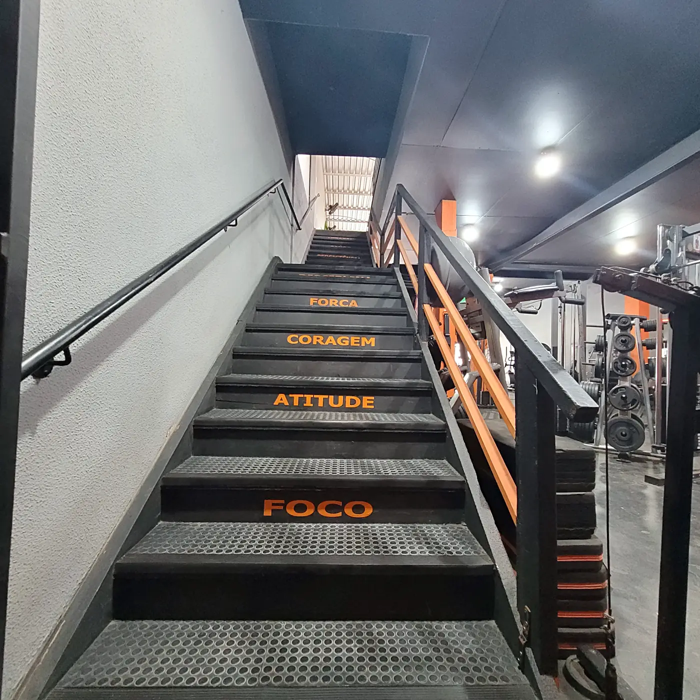 Escada com os degraus FOCO, ATITUDE, CORAGEM e FORÇA que leva à área de artes marciais